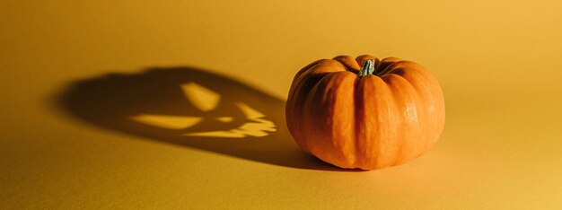 Concepto de fondo de Halloween. Sombra de cara enojada de calabaza de Jack O. Espeluznante sombra sonriente de una vista superior de linterna de calabaza naranja de cerca, diseño de fiesta de Halloween