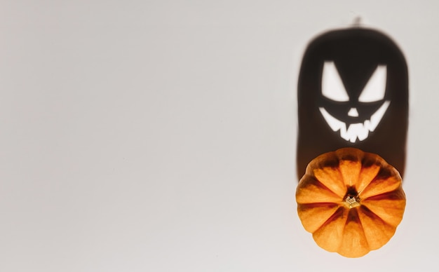 Concepto de fondo de Halloween. Sombra de cara enojada de calabaza de Jack O. Espeluznante sombra sonriente de una vista superior de linterna de calabaza naranja de cerca, diseño de fiesta de Halloween