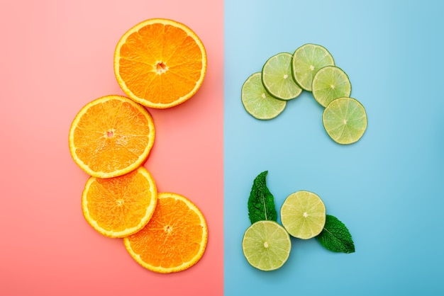 Concepto de fondo de verano en rodajas de naranja, pomelo, limón, lima sobre fondo rosa y azul