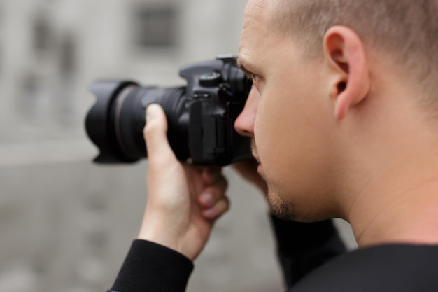 Foto concepto de fotografía vista posterior del fotógrafo masculino tomando fotos con una cámara réflex digital moderna