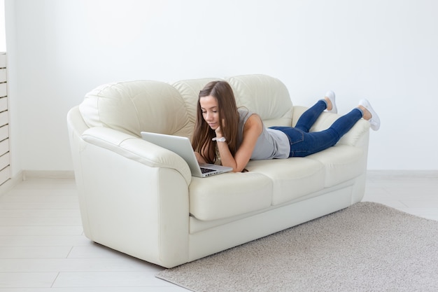 Concepto de freelance y personas - mujer joven que trabaja en la computadora portátil en casa