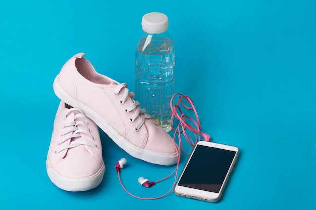 Concepto de funcionamiento y estilo de vida saludable. qué llevar a correr: zapatillas, agua, teléfono inteligente y auriculares