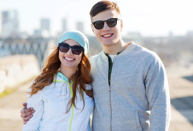 concepto de gente, amor y amistad - pareja adolescente feliz caminando en la ciudad