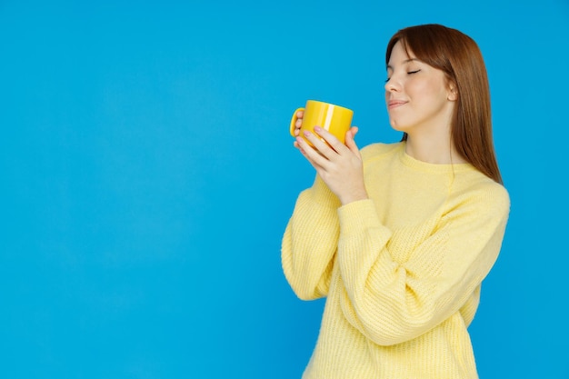 Concepto de gente chica con taza sobre fondo azul.