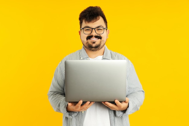 Concepto de gente joven gordo con laptop sobre fondo amarillo