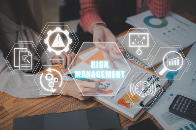 Concepto de gestión de riesgos Equipo de negocios analizando datos financieros en papel de negocio con icono de gestión de riesgo en pantalla virtual Estándar Análisis de estrategia de monitoreo Proyecto de evaluación de control