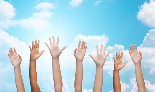 Foto concepto de gesto, saludo, caridad y partes del cuerpo - gente agitando las manos sobre el cielo azul y el fondo de las nubes blancas