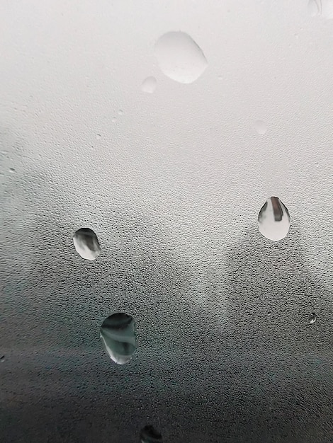 Concepto de gotas de lluvia cayendo sobre un fondo gris. Superficie blanca húmeda abstracta con burbujas