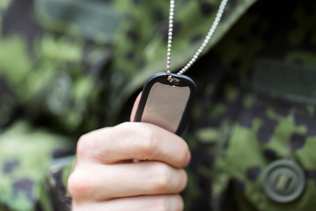 concepto de guerra, ejército y gente - cerca de un joven soldado con uniforme militar