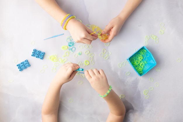 Concepto de hacer pulseras de telar por niños azul y amarillo foto de alta calidad