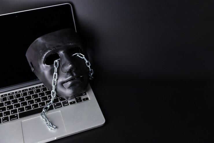 Foto concepto de hackers y delitos cibernéticos, máscara negra con cadena en computadora nueva sobre fondo negro