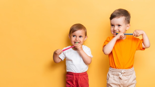 El concepto de higiene dental. Hermano y hermana se cepillan los dientes junto con un cepillo de dientes. Espacio para el texto. Prevención de caries