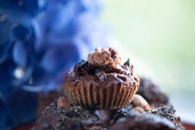 Concepto de horneado de cupcakes Elegantes cupcakes en un plato rodeados de hortensias azules