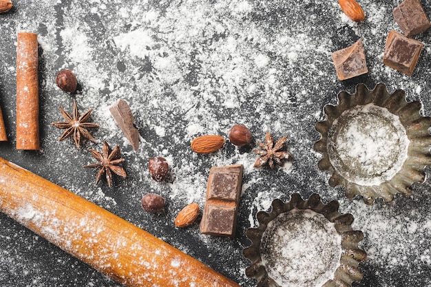 Concepto de horneado forma de cupcake e ingredientes alimentarios sobre un fondo oscuro prepararse para cocinar vista superior