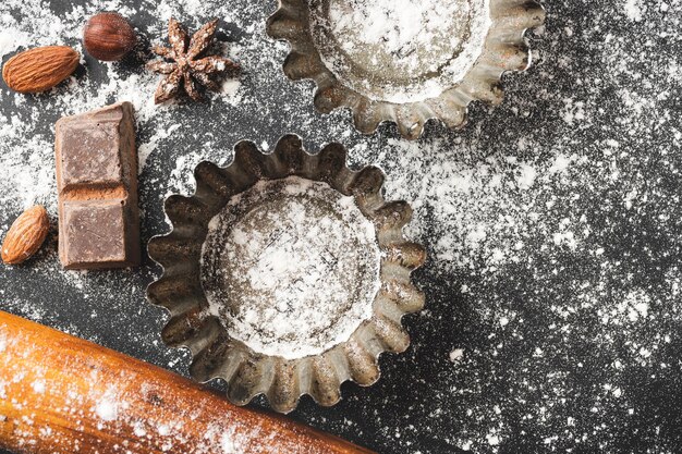 Concepto de horneado forma de cupcake e ingredientes alimentarios sobre un fondo oscuro prepararse para cocinar vista superior