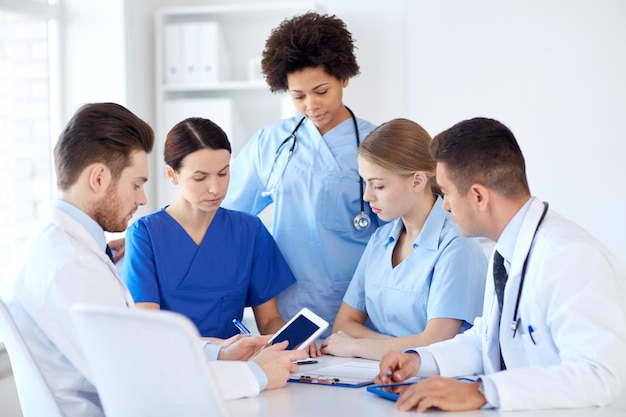 concepto de hospital, profesión, personas y medicina - grupo de médicos con tabletas reunidas en el consultorio médico