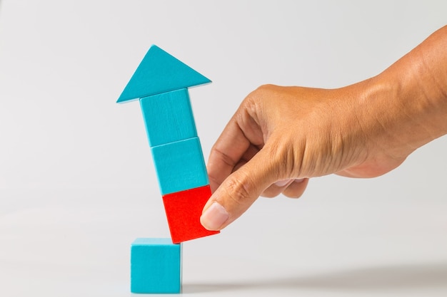 Concepto de ideas de disrupción empresarial. El hombre tirando de la mano del bloque de madera roja del bloque de madera azul