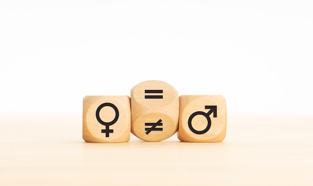 Concepto de igualdad de género. Bloque de madera que convierte un signo desigual en un signo igual entre los símbolos de hombres y mujeres. Copia espacio