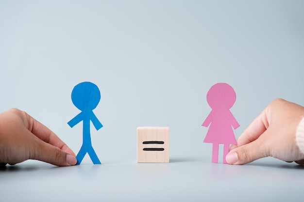 Concepto de igualdad de hombre y mujer usando bloque de madera y letrero de corte de papel