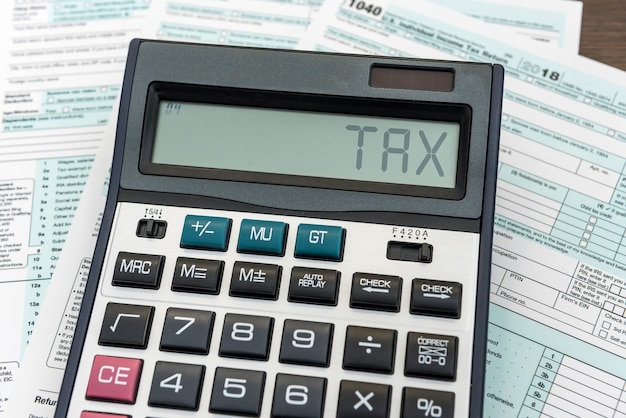 Concepto de impuestos Formulario de impuestos 1040 con calculadora en el escritorio. Tiempo de financiación