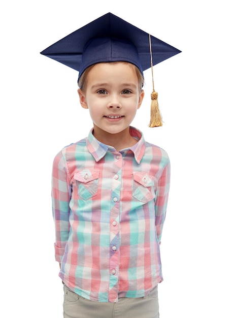 concepto de infancia, escuela, educación, aprendizaje y personas - niña feliz con sombrero de soltero o birrete