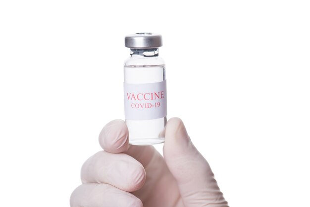 Concepto de inmunización y tratamiento. Primer plano macro foto recortada del médico terapeuta practicante profesional sosteniendo un frasco de vacuna COVID-19 aislado sobre fondo blanco.
