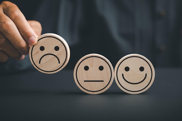 concepto de insatisfacción del cliente el cliente sostiene el icono fruncido en un círculo de madera que simboliza la poca satisfacción que representa a un cliente infeliz retroalimentación negativa y decepción