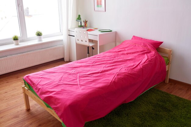 Foto concepto de interior, hogar y mobiliario - habitación para niños con cama, mesa y accesorios