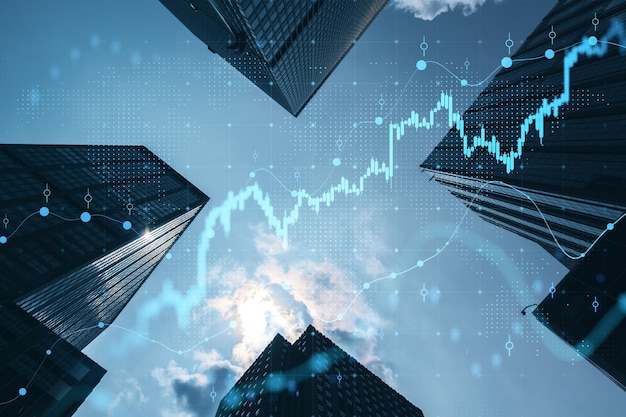 Concepto de inversión y bienes raíces con vista inferior en las cimas de los rascacielos soleados y gráfico financiero digital con diagrama del mercado de valores