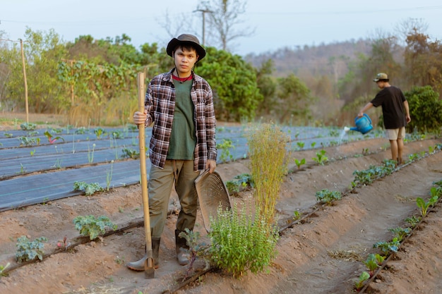 Concepto de jardinería: un joven agricultor que palea la tierra alrededor de las plantas para permitir que el oxígeno pase fácilmente por las raíces.