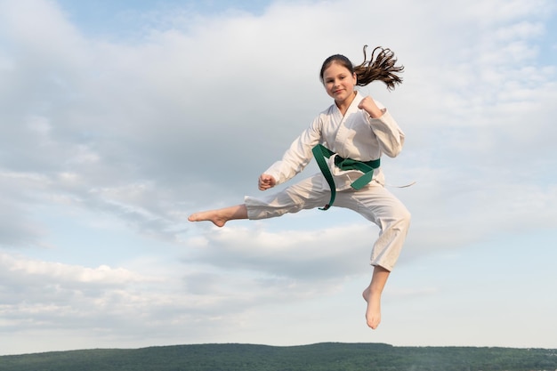 Concepto de judo jovencita practicando judo girl judo fighter sobre fondo de cielo