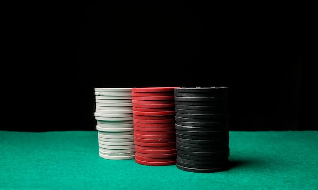 Concepto de juego de póquer. Concepto de casino o juegos de azar. Pila de fichas de póquer en una mesa de póquer de juego verde.