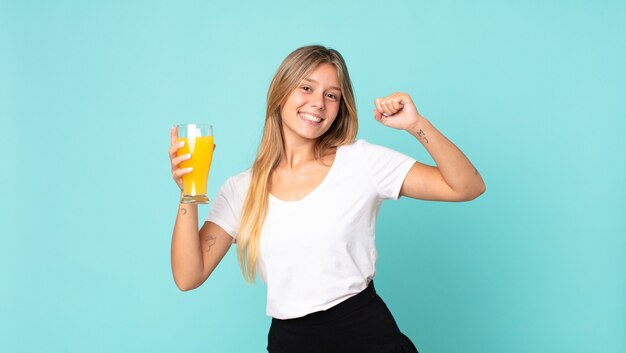 Concepto de jugo de naranja bastante joven mujer rubia