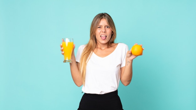 Concepto de jugo de naranja bastante joven mujer rubia