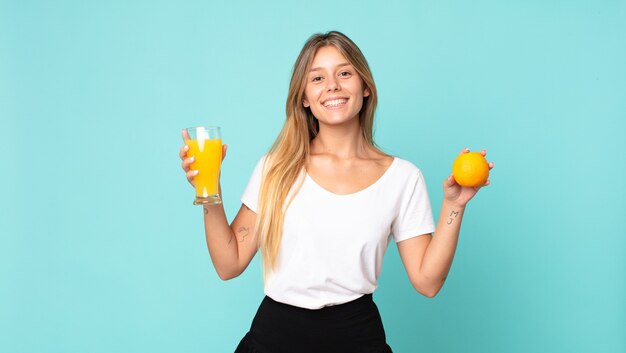 Concepto de jugo de naranja bastante joven mujer rubia