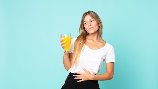 Concepto de jugo de naranja bastante joven mujer rubia