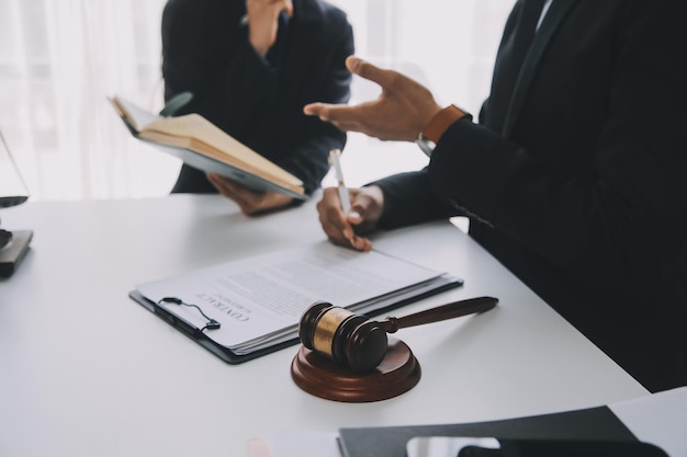 Concepto de justicia y derecho El asesor legal presenta al cliente un contrato firmado con un martillo y una ley legal o legal con una reunión de equipo en un bufete de abogados en el fondo