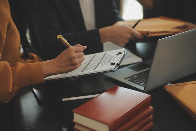 Foto concepto de justicia y derecho el asesor legal presenta al cliente un contrato firmado con un martillo y una ley legal o legal con una reunión de equipo en un bufete de abogados en el fondo