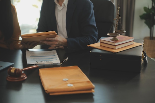 Concepto de justicia y derecho El asesor legal presenta al cliente un contrato firmado con un martillo y una ley legal o legal con una reunión de equipo en un bufete de abogados en el fondo