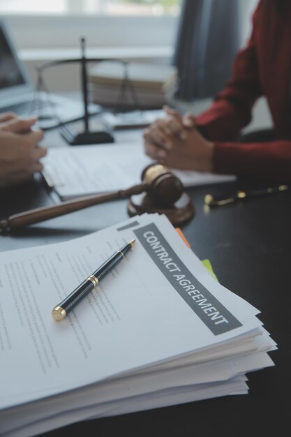 Concepto de justicia y derechoJuez masculino en una sala de audiencias con el mazo trabajando con computadora y anteojos de teclado de acoplamiento en la mesa a la luz de la mañana