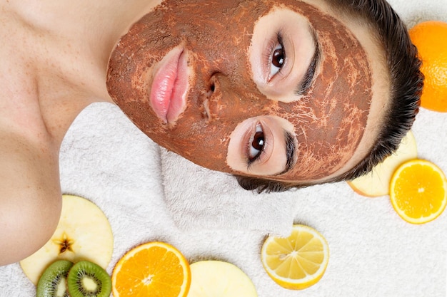 Foto concepto de juventud y belleza de la gente de la salud de primavera mascarillas faciales de frutas caseras naturales fruta fresca spa mujer aplicando máscara de limpieza facial tratamientos de belleza