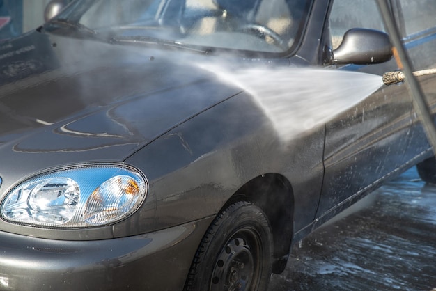 Concepto de lavado de autos lavado de autos con pistola de agua de alta presión