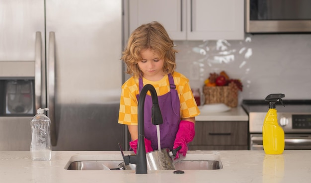 Concepto de lavado y limpieza niño ayuda a lavar los platos en la cocina niño limpieza de kithen ayuda ingenio