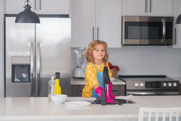 Concepto de lavado y limpieza niño ayudando con el hogar limpiando platos en la cocina niño ayudante hous