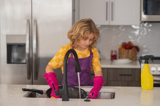 El concepto de lavado de platos retrato de la limpieza del niño en la cocina en el desarrollo del concepto de crecimiento en el hogar