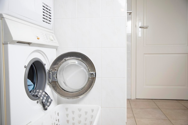 Concepto de lavandería Lavadora blanca y moderna con puerta abierta dentro de un apartamento luminoso o