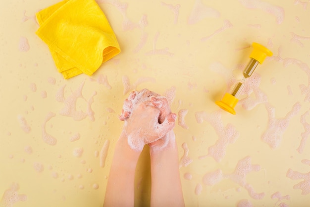 Concepto de lavarse las manos lavarse las manos en casa concepto de coronavirus manos del niño en espuma en amarillo de alta calidad ...