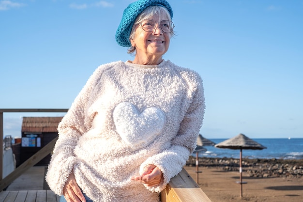 Concepto de libertad y felicidad personas con hermosa mujer mayor madura caucásica al aire libre disfrutando del lugar de destino disfrutando de la playa del mar relajarse cielo azul Copiar espacio