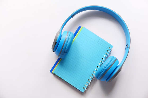 Concepto de libro de audio con auriculares y bloc de notas