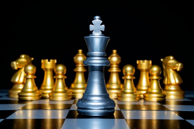 Concepto de liderazgo de ajedrez con piezas de ajedrez de plata y oro aisladas en fondo negro